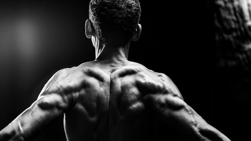Dynamic black and white portrait highlighting muscular physique and body definition.
